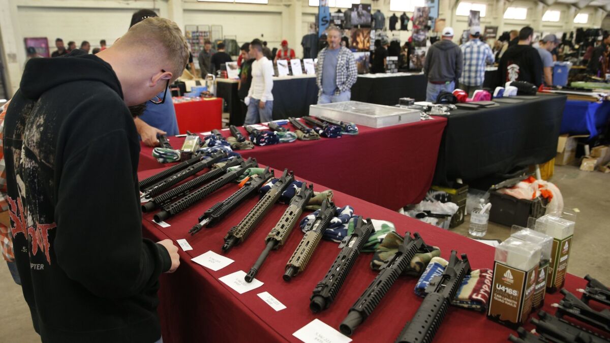 Gun enthusiasts check out semi-automatic rifle parts at a 2015 gun show at the Del Mar fairgrounds run by Crossroads of the West. The company runs shows across California, including those at the Ventura County fairgrounds.