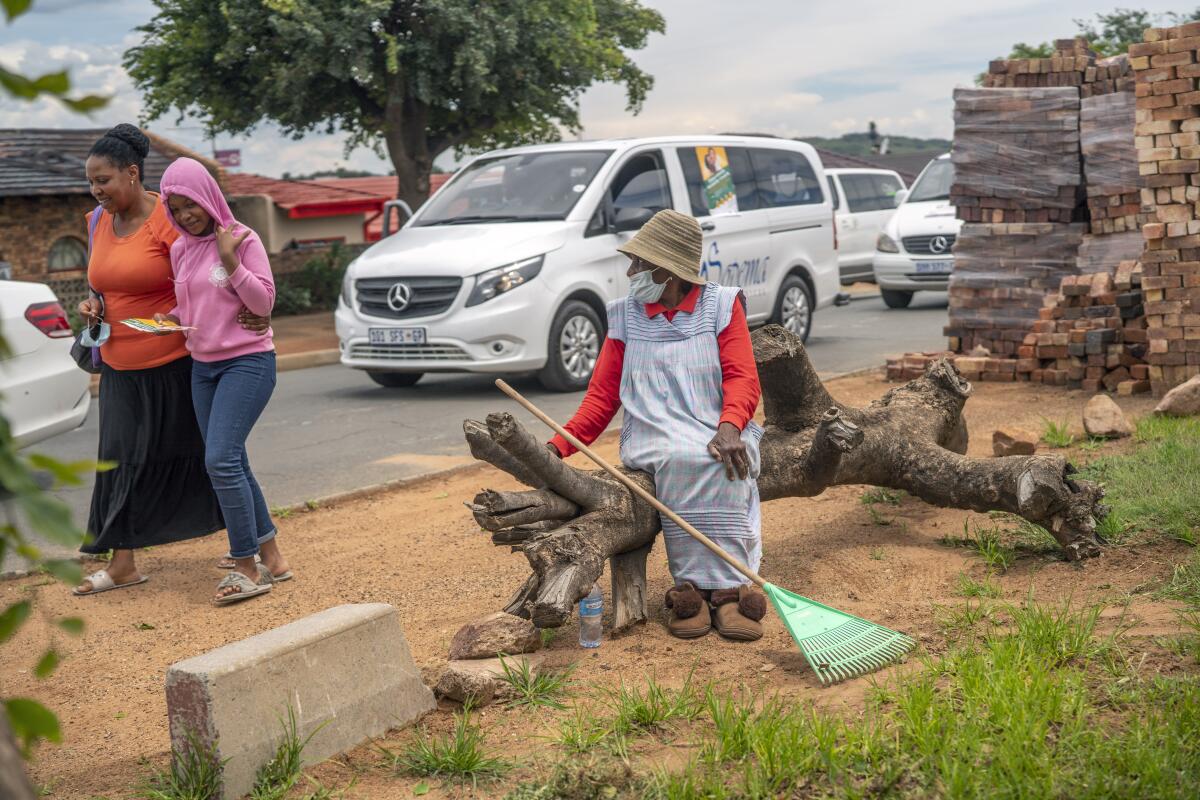 A woman watches hearses drive in convoy