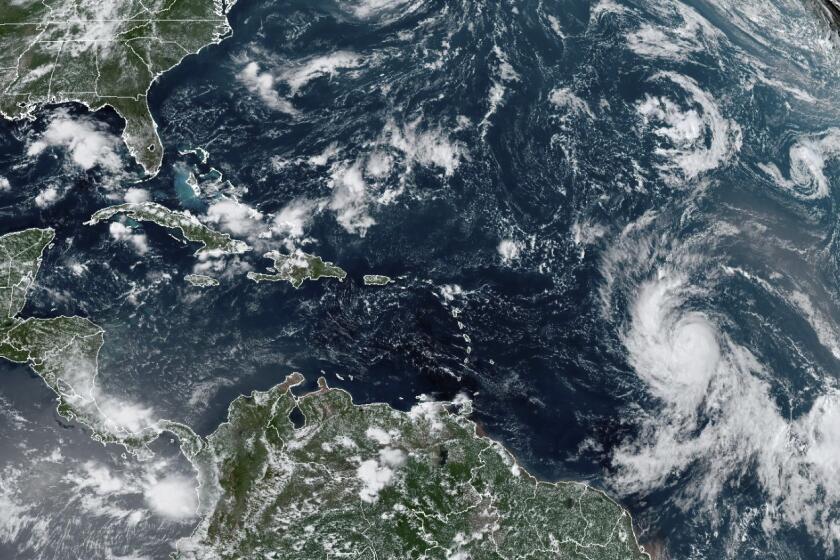 This Wednesday, Sept. 6, 2023, satellite image provided by the National Oceanic and Atmospheric Administration shows Hurricane Lee, right, off in the central tropical Atlantic Ocean. (NOAA via AP)