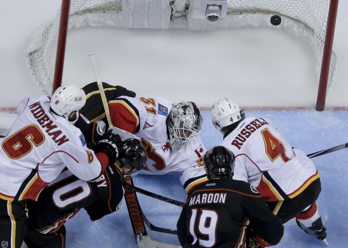 Ducks forward Corey Perry slips the puck past Flames goalie Karri Ramo in overtime to give Anaheim a 3-2 victory in overtime.
