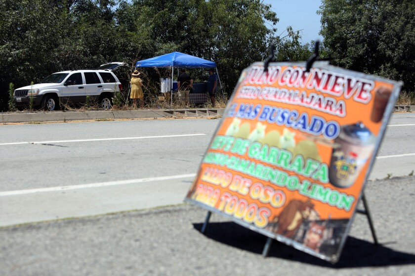 Fredy Hernandez sells Tejuino Con Nieve--a drink from Guadalajara--and other cold treats at one of two stands he works at.