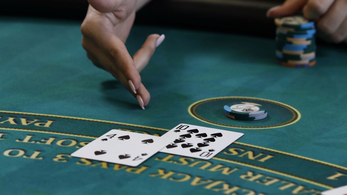 Hit me! An important part of learning how to play blackjack is to know the hand signals players are required to use. Here, with a 14 showing, the player motions for another card, or a hit, with a brushing motion toward her.