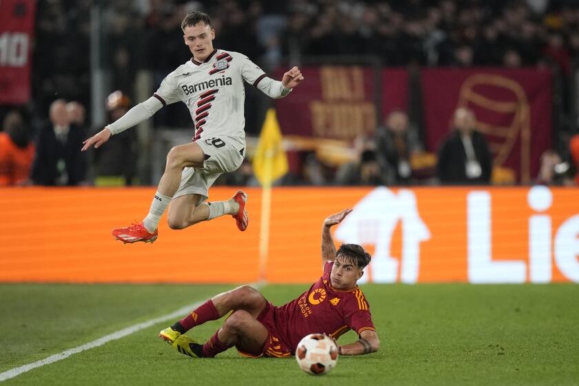 Leverkusen's Florian Wirtz, top, is challenged by Roma's Paulo Dybala during the Europa League semifinal first leg soccer match between Roma and Bayer Leverkusen at Rome's Olympic Stadium in Rome, Italy, Thursday, May 2, 2024. (AP Photo/Andrew Medichini)