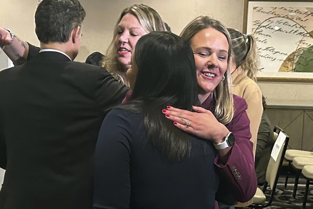 Two women hug.