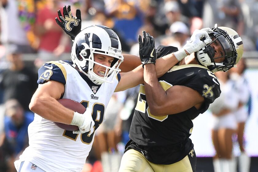 LOS ANGELES, CALIFORNIA SEPTEMBER 15, 2019-Rams Cooper Kupp stiff-arms Saints Marshon Lattimore for a catch a big gain in the 4th quarter at the Coliseum Sunday. (Wally Skalij/Los Angeles Times)