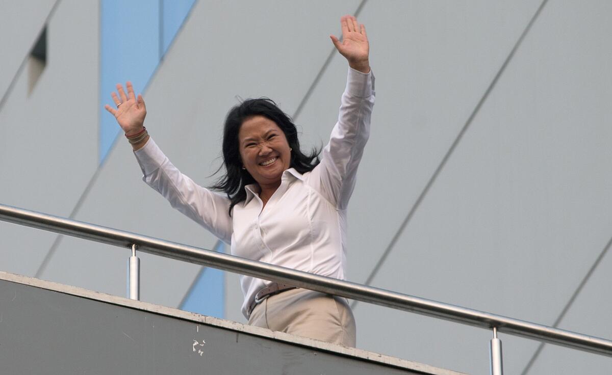Presidential candidate Keiko Fujimori waves to supporters from her Lima hotel while awaiting the results of Peru's presidential election on April 10, 2016.