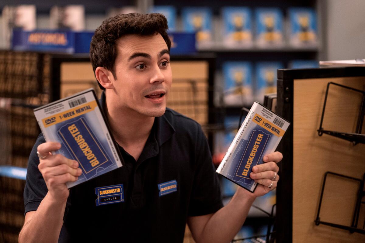Actor Tyler Alvarez as Carlos, holding DVDs, in an episode of "Blockbuster.