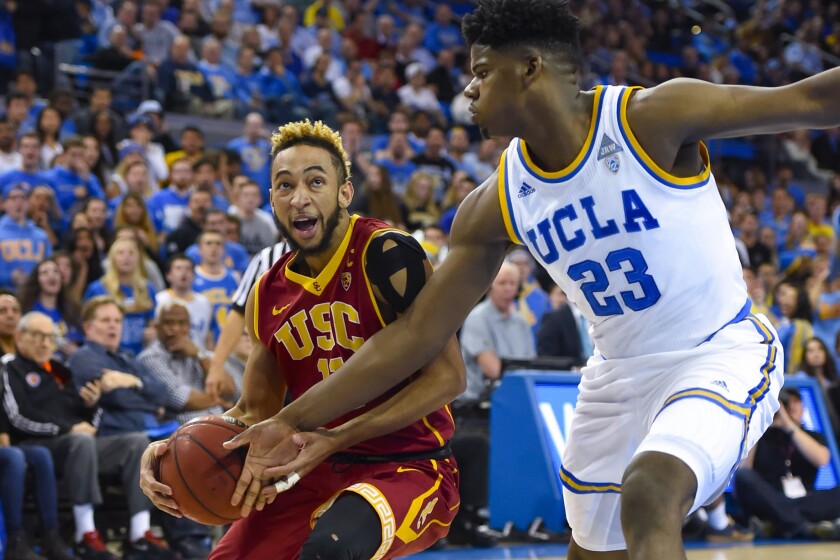 USC guard Jordan McLaughlin (11) drives down the lane against UCLA forward Tony Parker (23) during the first half.