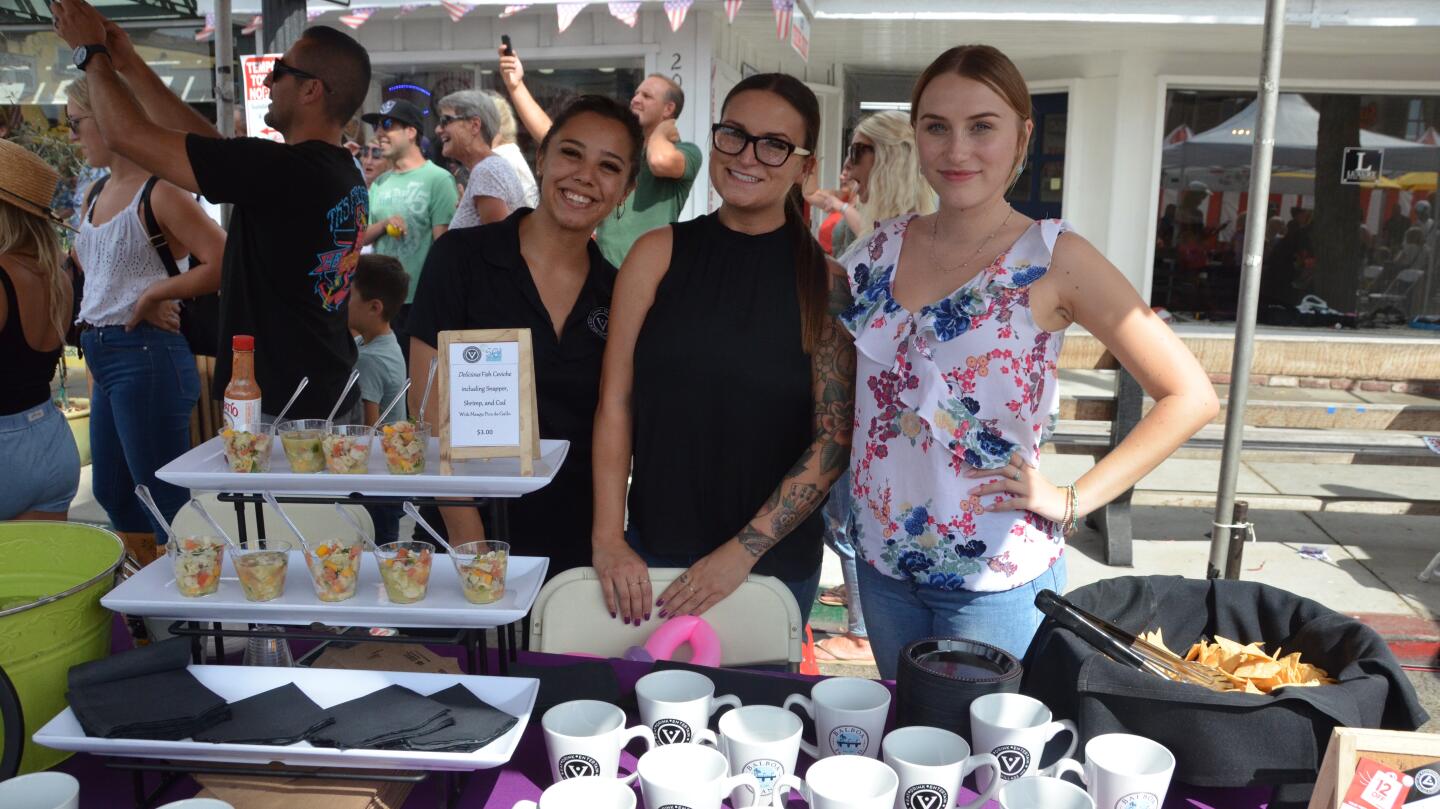 Bree Komadina, Britney Forbes and McKenna Cote, from left, serve ceviche from the Village Inn as part of the Balboa Island Carnival & Taste of the Island on Sunday.