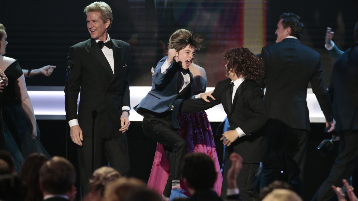 Actor Finn Wolfhard leaps for joy after winning Ensemble in a Drama Series.