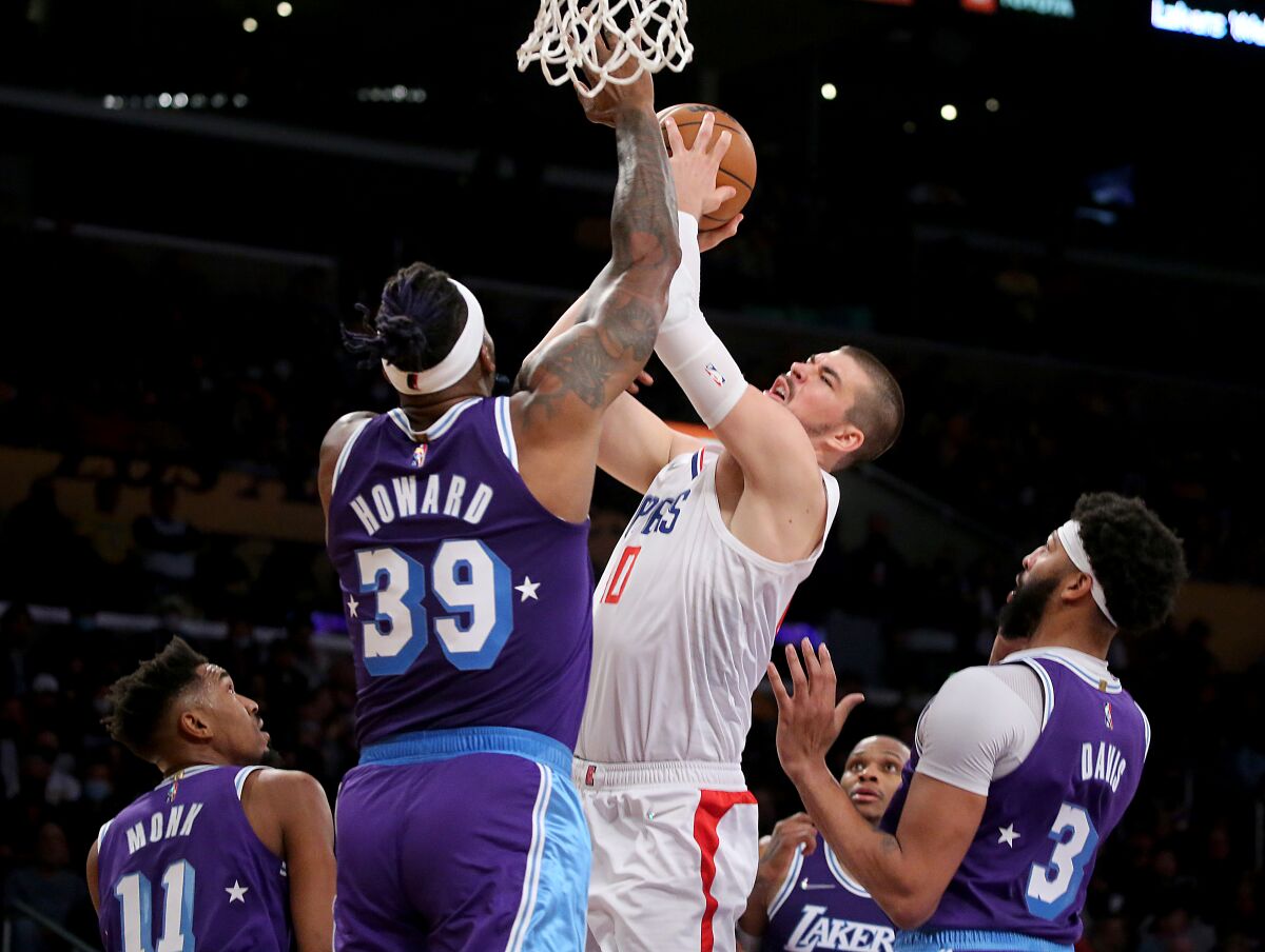Lakers center Dwight Howard challenges a shot by Clippers center Ivaca Zubac.