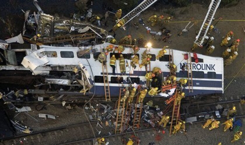 Rescue personnel work at the scene of a train crash in Los Angeles, Friday, Sept. 12, 2008. A Metrolink commuter train believed to be carrying up to 350 people collided with a freight train Friday, killing four people and injuring dozens of others. (AP Photo/Hector Mata)