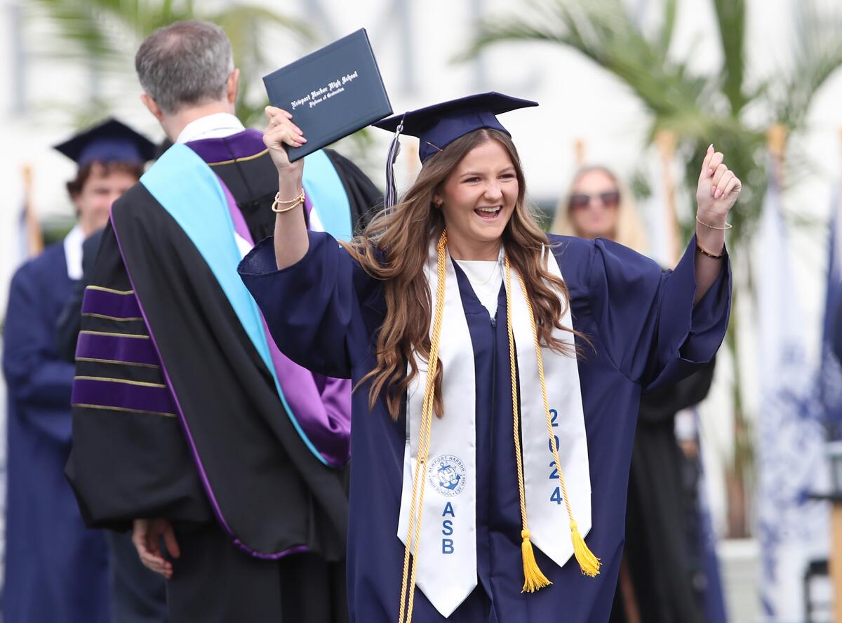 Olivia Nott happily receives her diploma during the 93rd annual Newport Harbor graduation.