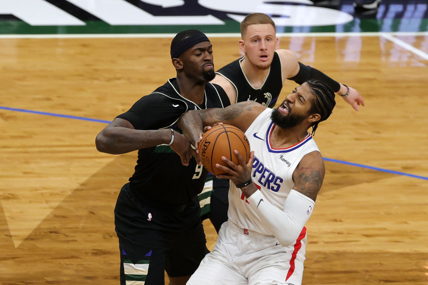 Clippers forward Paul George tries to drive past Milwaukee's Bobby Portis and Donte DiVincenzo.