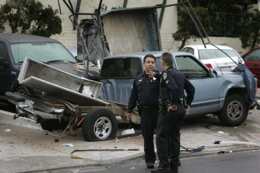 June 10, 2010- SAN DIEGO CA- Two San Diego Police officers stand near the pickup truck on Altadena Avenue near Orange Avenue in Talmadge that hit a police car broadside, and hit more than eight parked vehicles during a police pursuit before 5 a.m. today, June 10, 2010. One of the two injured officers in the patrol car was trapped and was rescued by San Diego Fire-Rescue Department firefighters. The suspect was injured and taken to the hospital as well. Photo by Howard Lipin/San Diego Union-Tribune) Mandatory Photo Credit: HOWARD LIPIN/ San Union-Tribune/ZUMApress.com