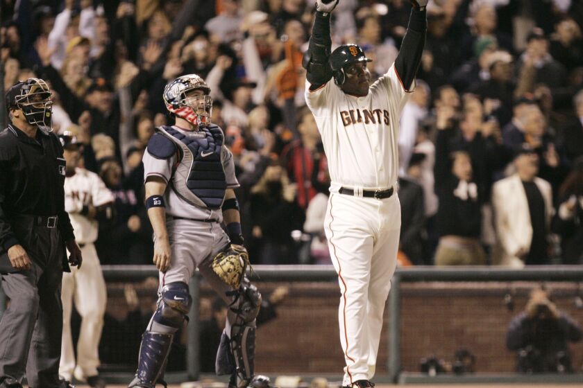 FILE - San Francisco Giants' Barry Bonds celebrates after hitting his 756th career home run against the Washington Nationals during the fifth inning of their baseball game in San Francisco, on Aug. 7, 2007. Barry Bonds, Roger Clemens and David Ortiz appear to be the only players with a chance at Hall of Fame enshrinement when results are unveiled Tuesday, Jan. 25, 2022, with Ortiz most likely to get in on his first try. Bonds and Clemens are each in their 10th and final turns under consideration by voters from the Baseball Writers' Association of America. (AP Photo/Eric Risberg, file)