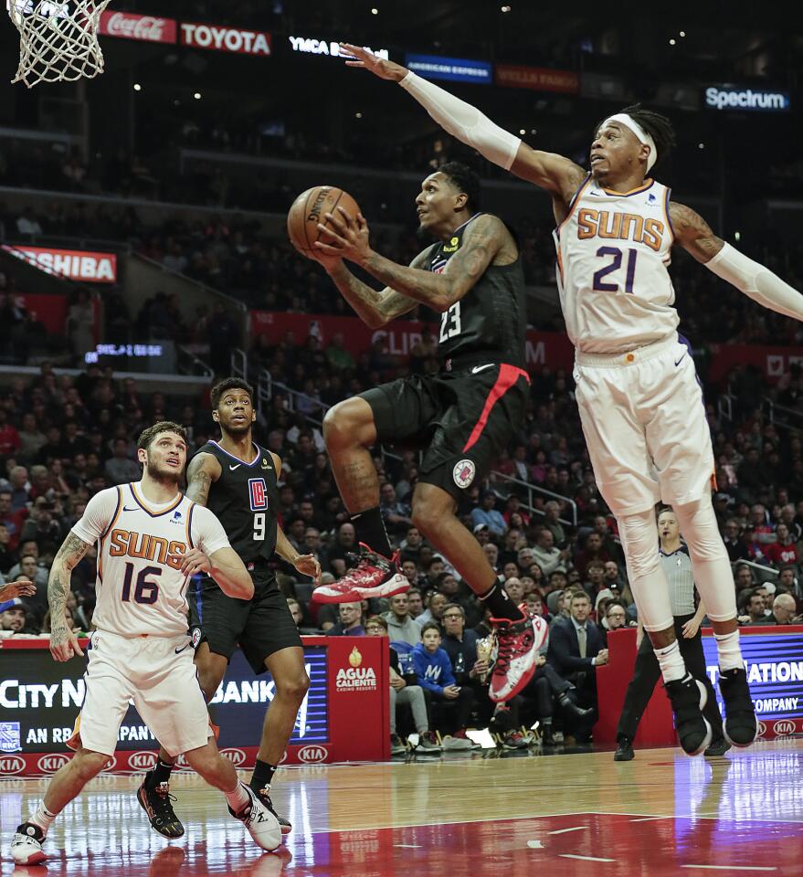 Clippers guard Lou Williams drives past Suns forward Richaun Holmes for a basket during the first half of the Clippers' 134-107 win at Staples Center.