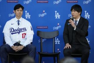 Dodgers' Shohei Ohtani, left, and interpreter Ippei Mizuhara answer questions during a news conference at Dodger Stadium