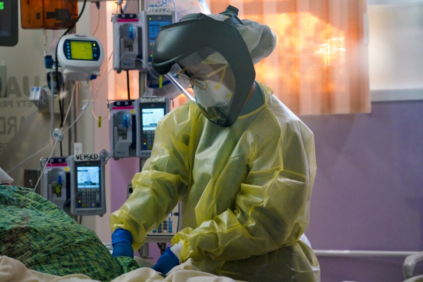 Vanessa Malibago, a registered nurse working in the ICU at Scripps Mercy Hospital Chula Vista, checks on her patient
