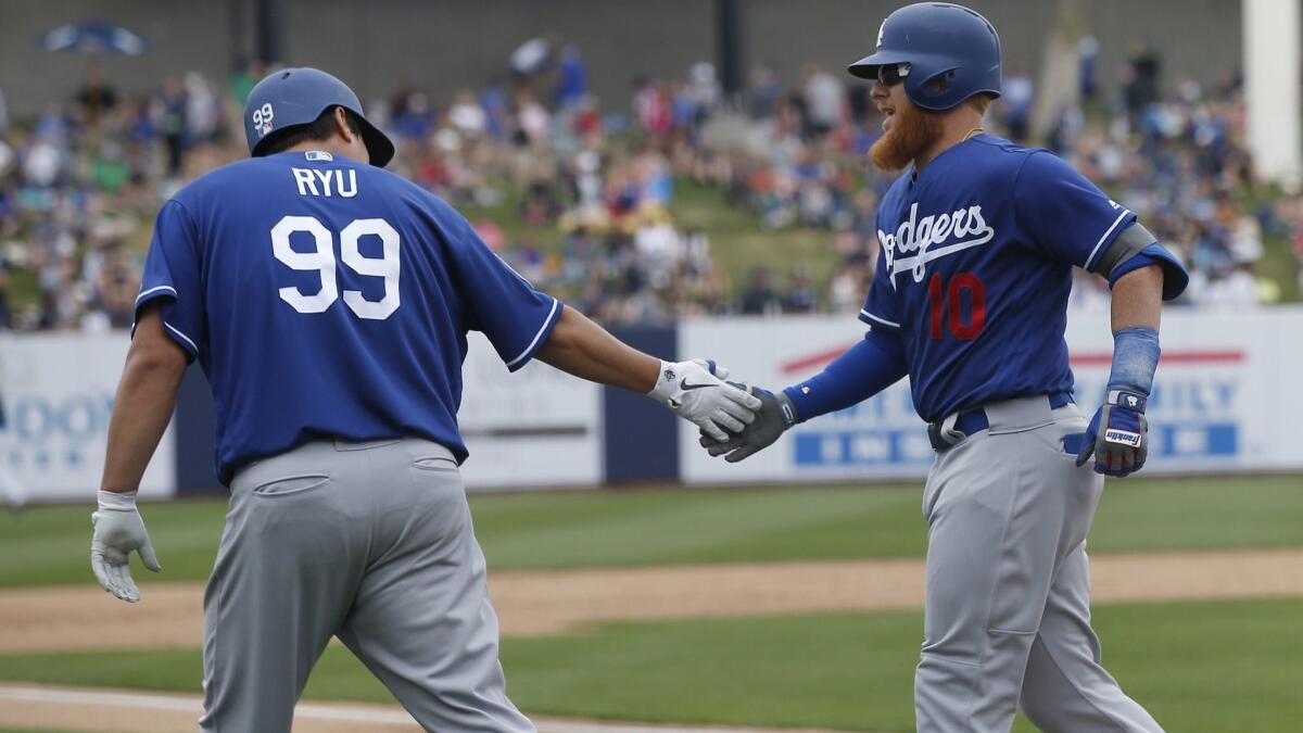 The Dodgers' Justin Turner is congratulated by pitcher Hyun-Jin Ryu after Turner's home run in a spring training game against the Brewers on Thursday in Phoenix.