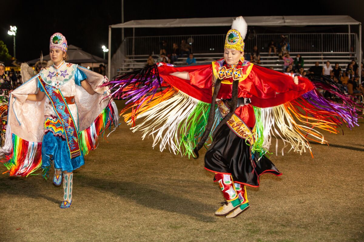 Two young women dance fancy shawl at the Barona Annual Powwow in 2019.