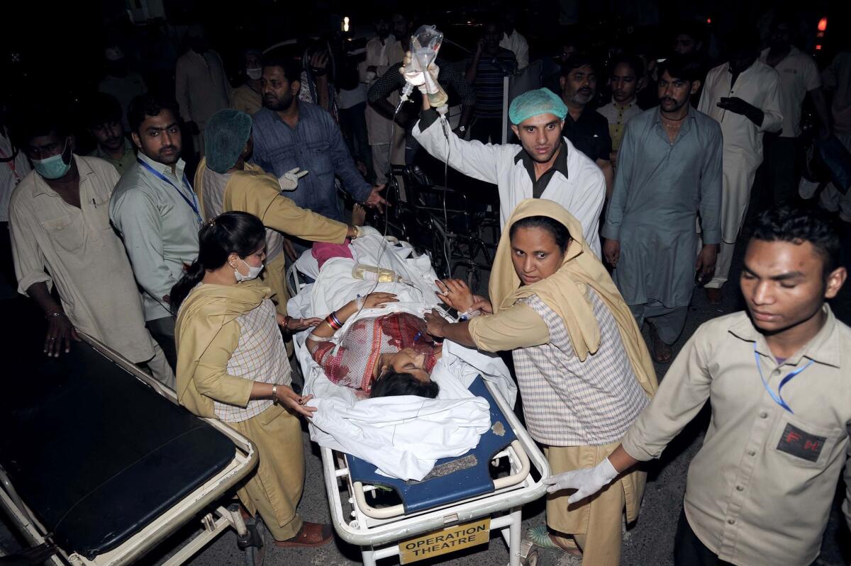 An injured woman is transported in Lahore, Pakistan, after a bombing at a park on Sunday.