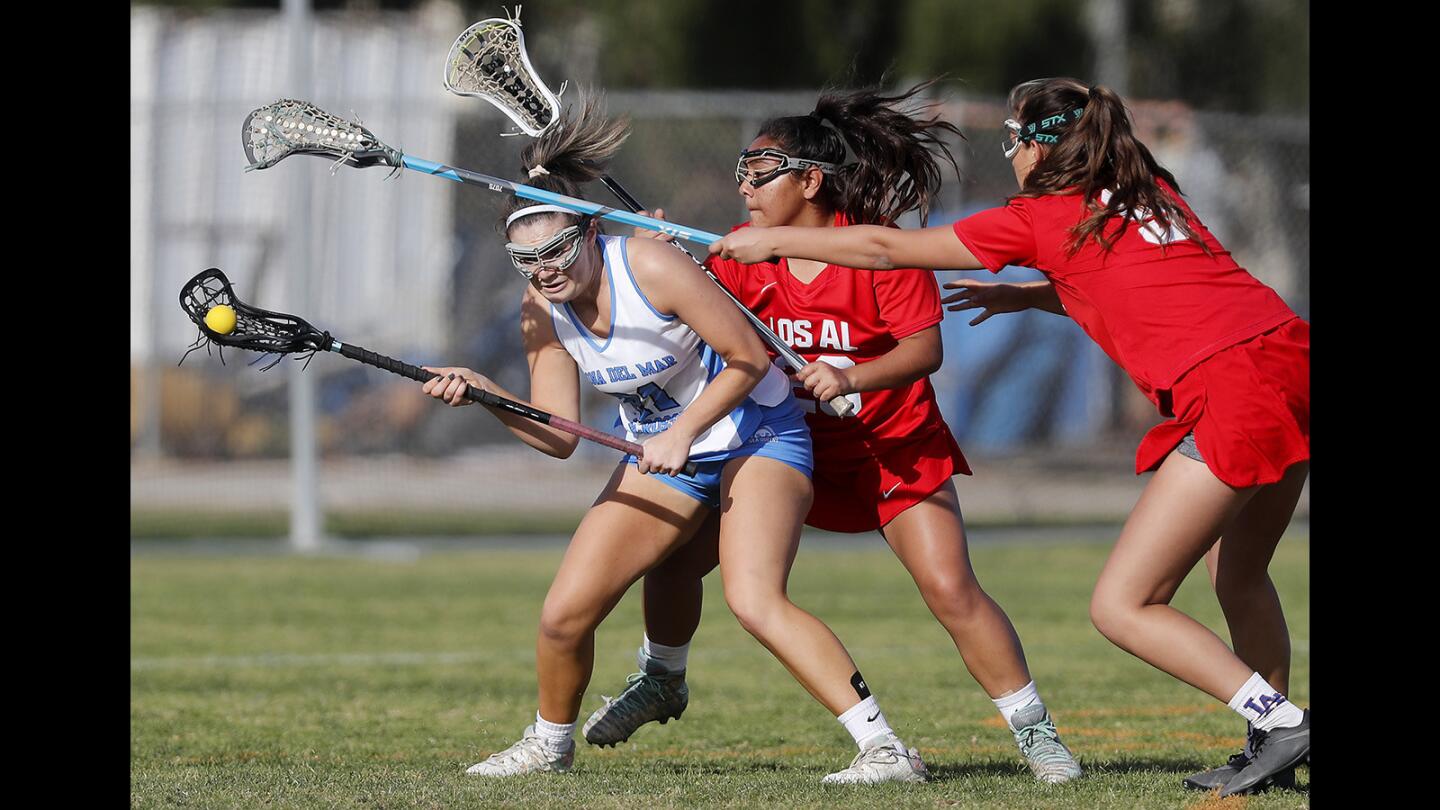 Corona del Mar High's Emily Faludy, left, battles against two Los Alamitos defenders during the first half in a nonleague match on Thursday, March 8.