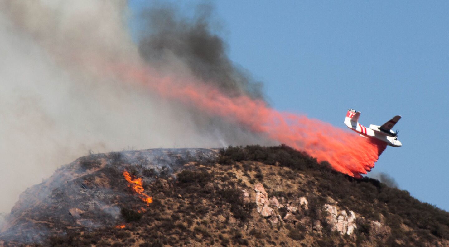 Fire retardant is dropped by an air tanker on flames from the Springs fire in Camarillo Springs.