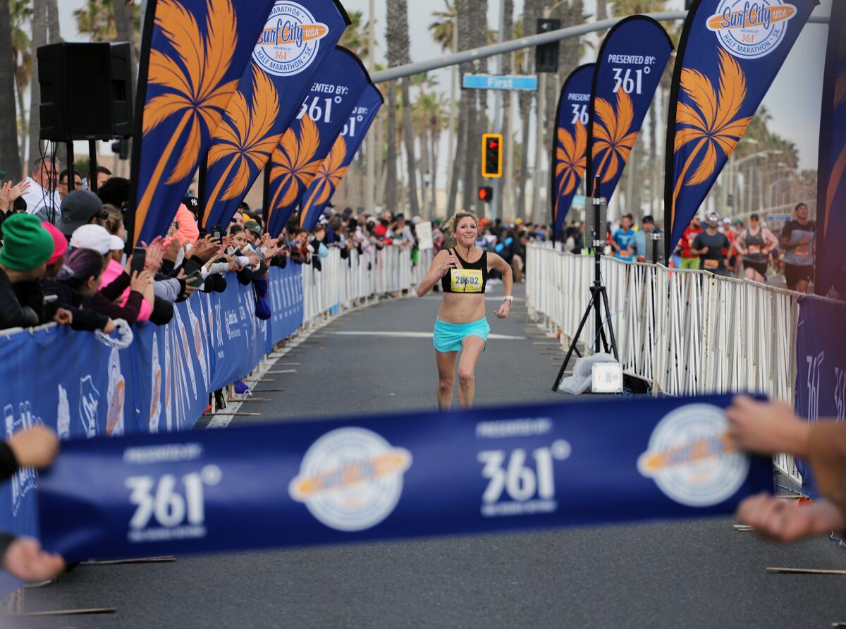 Michelle Jacobsen of Newport Beach sprints to the finish to win the women's Surf City Marathon on Sunday morning.