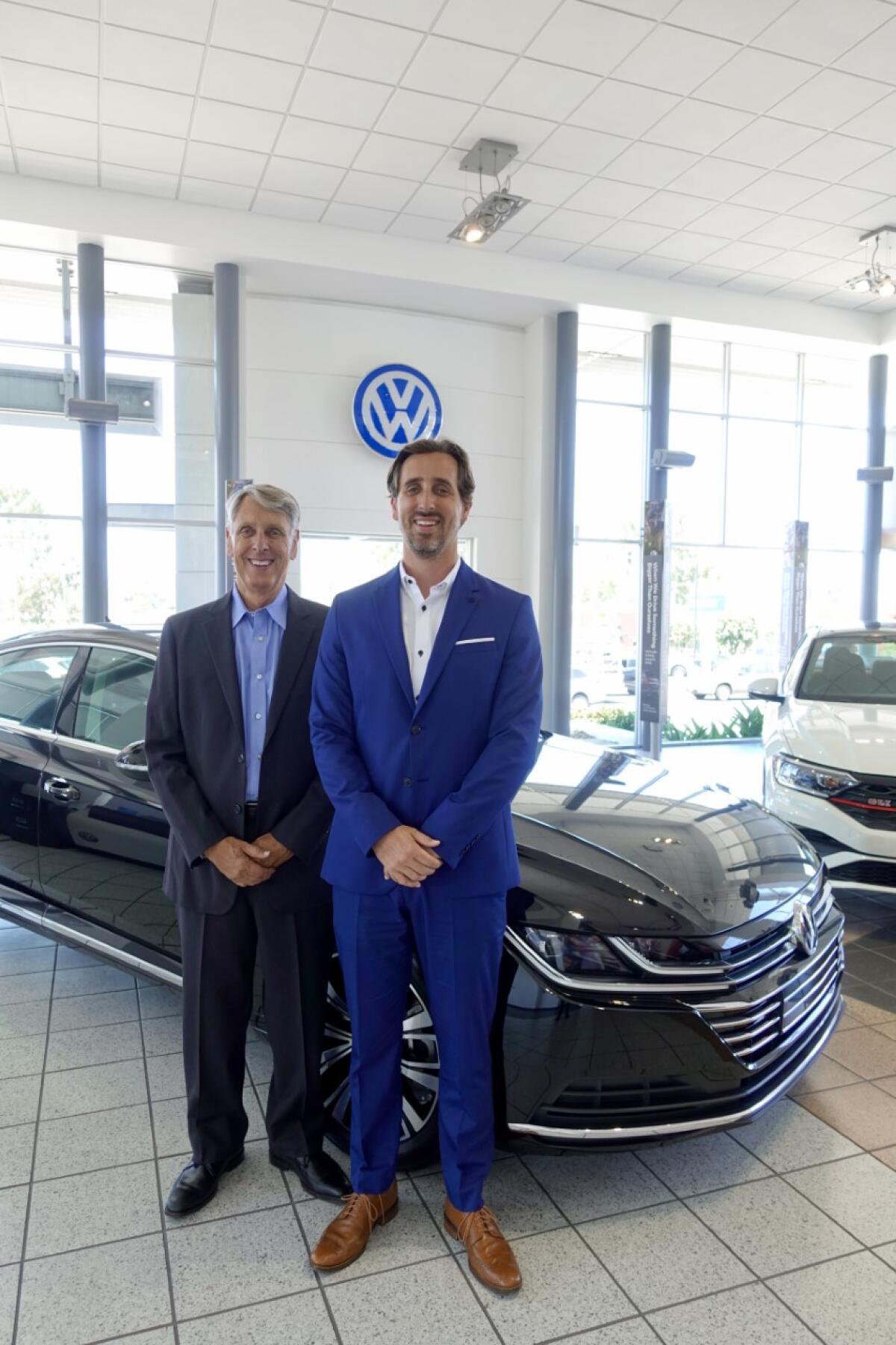Owner Dennis Cook and General Manager Connor Cook stand in the showroom of Herman Cook Volkswagen.