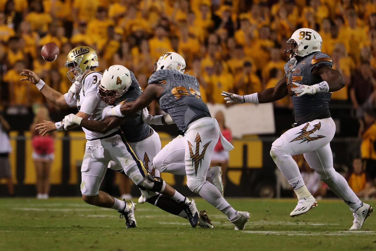 UCLA quarterback Josh Rosen (3) fumbles the football as he is sacked by Arizona State defensive lineman Koron Crump (4). Rosen was injured on the play and did not return.