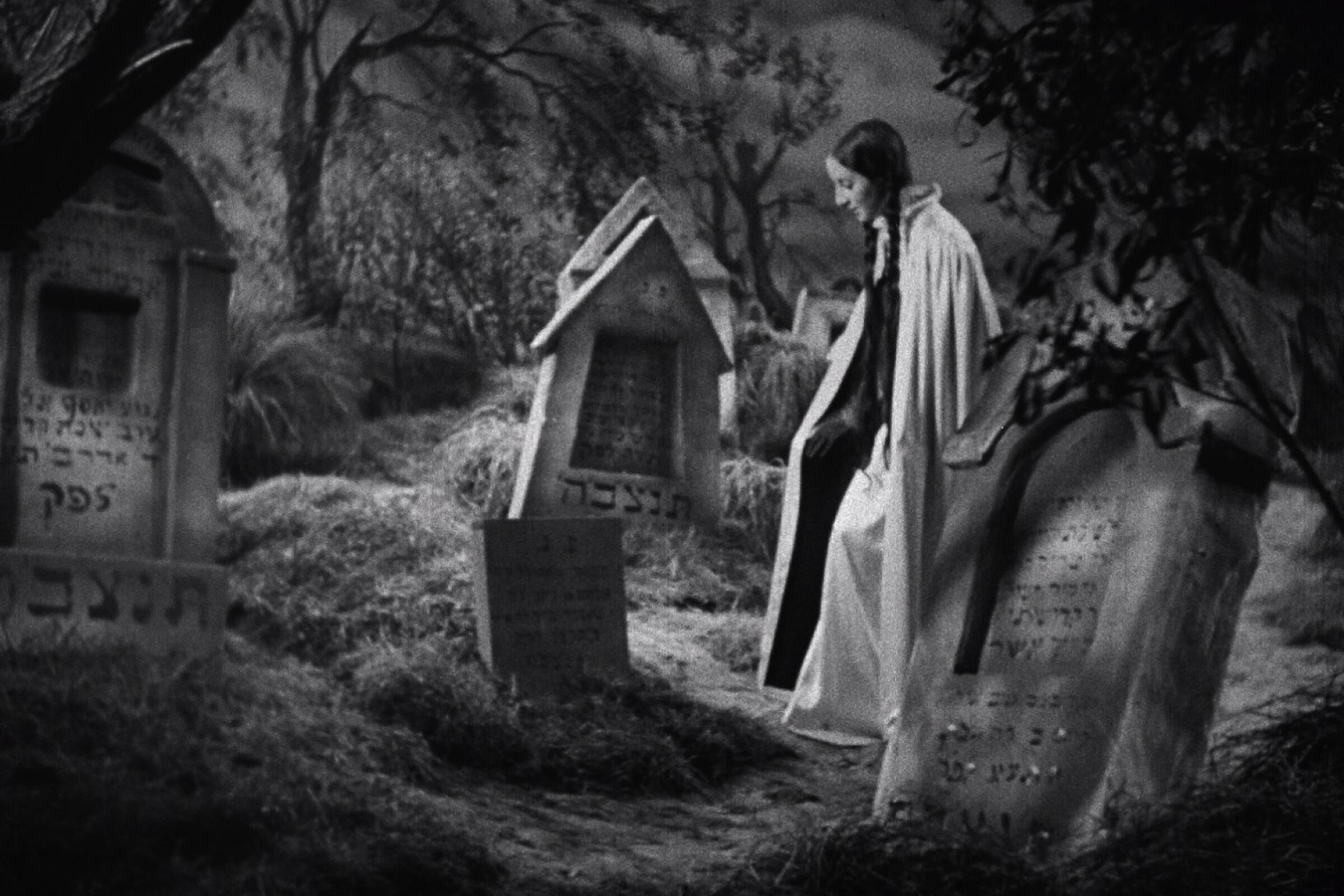 A woman visits a grave in the movie “The Dybbuk"