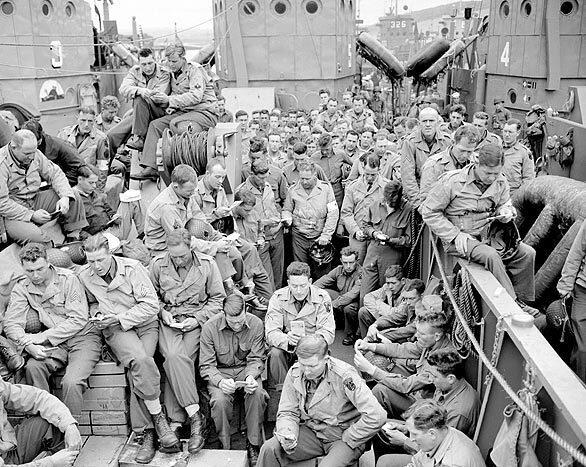 U.S. serviceman attend a Protestant service aboard a landing craft before the D-Day invasion on the coast of France, June 5, 1944.