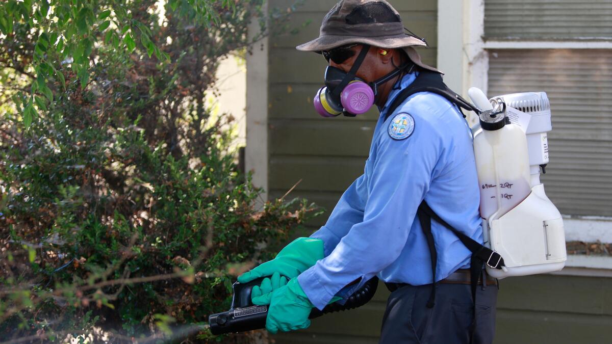 Sean Simmons, a vector control technician, sprays for the Zika virus at a home in the Mount Hope neighborhood of San Diego.