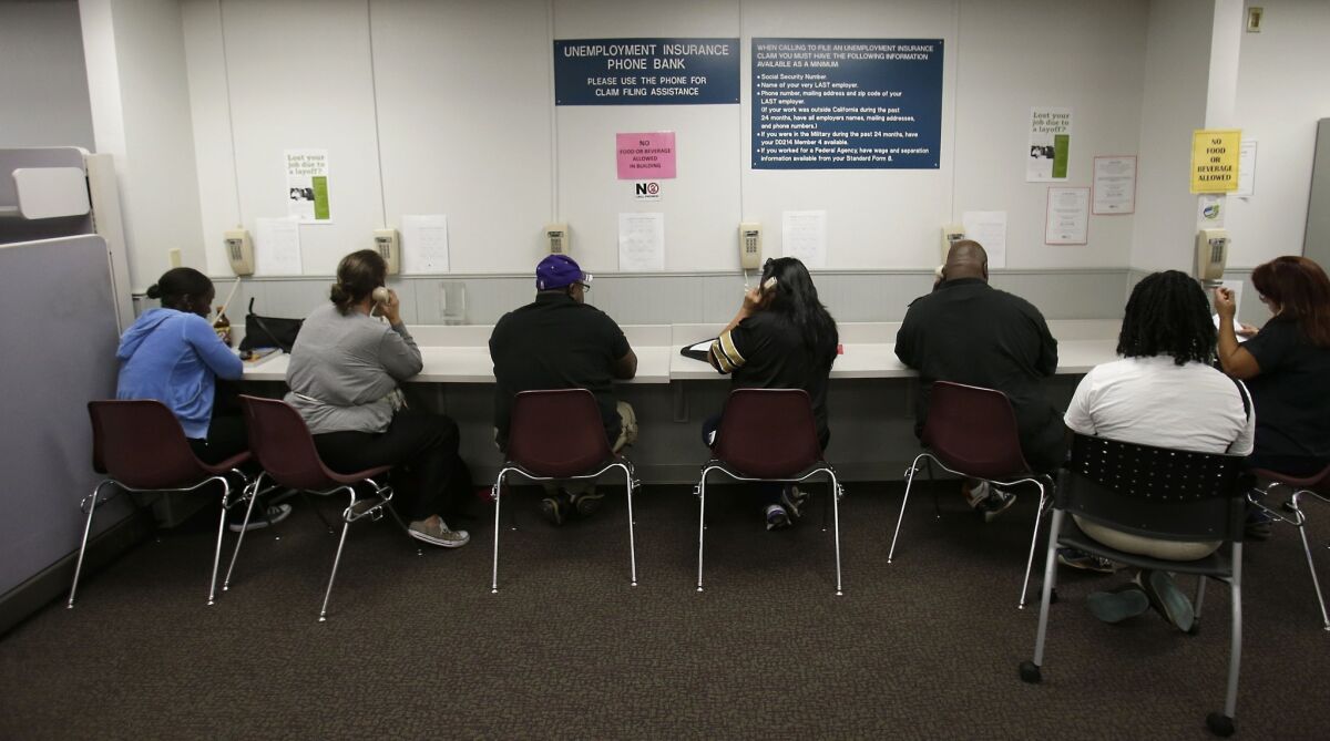 People out of work use the unemployment insurance phone bank at an Employment Development Department office in Sacramento.