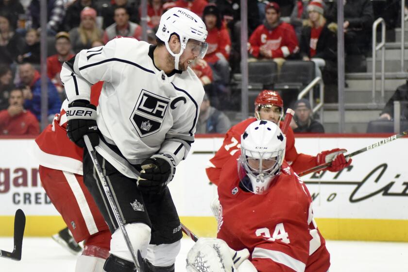 Los Angeles Kings center Anze Kopitar, left, of Slovenia, scores a goal past Detroit Red Wings goaltender Eric Comrie in the second period of an NHL hockey game Sunday, Dec. 15, 2019, in Detroit. (AP Photo/Jose Juarez)