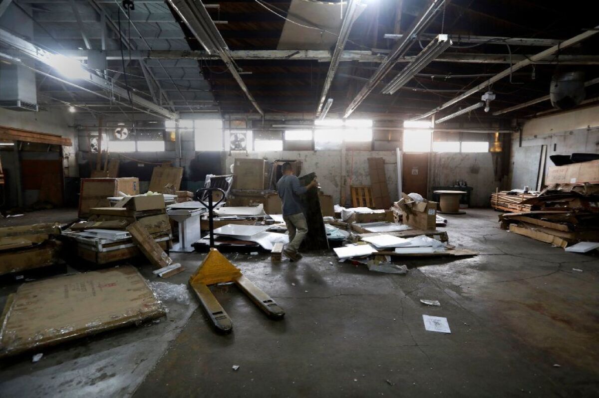 Workers clear out the warehouse that has been approved for marijuana production in El Monte.