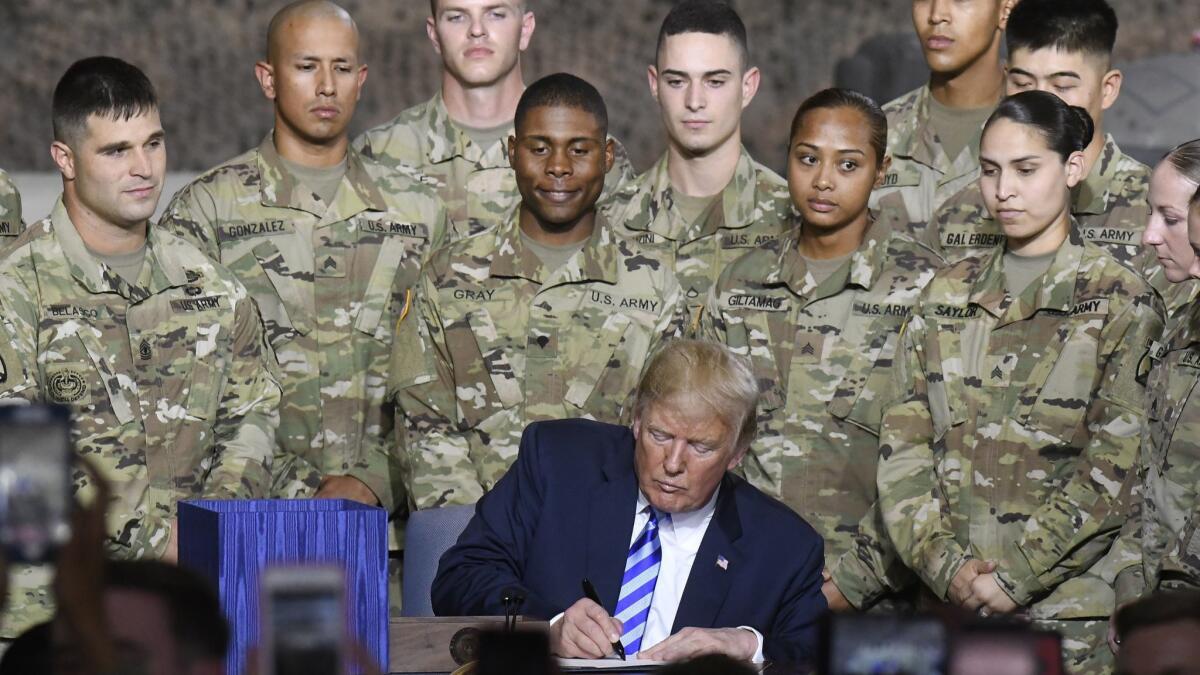 President Trump signs the John S. McCain National Defense Authorization Act in a ceremony at Ft. Drum, N.Y.
