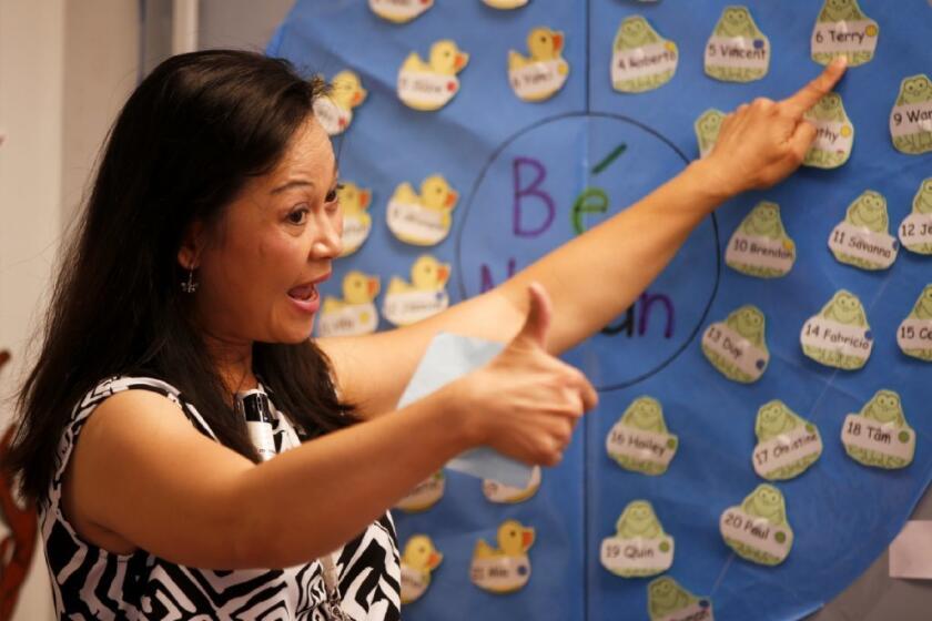 Kindergarten teacher Huong Dang starts her day by giving a thumbs-up to students who showed signs of good behavior.