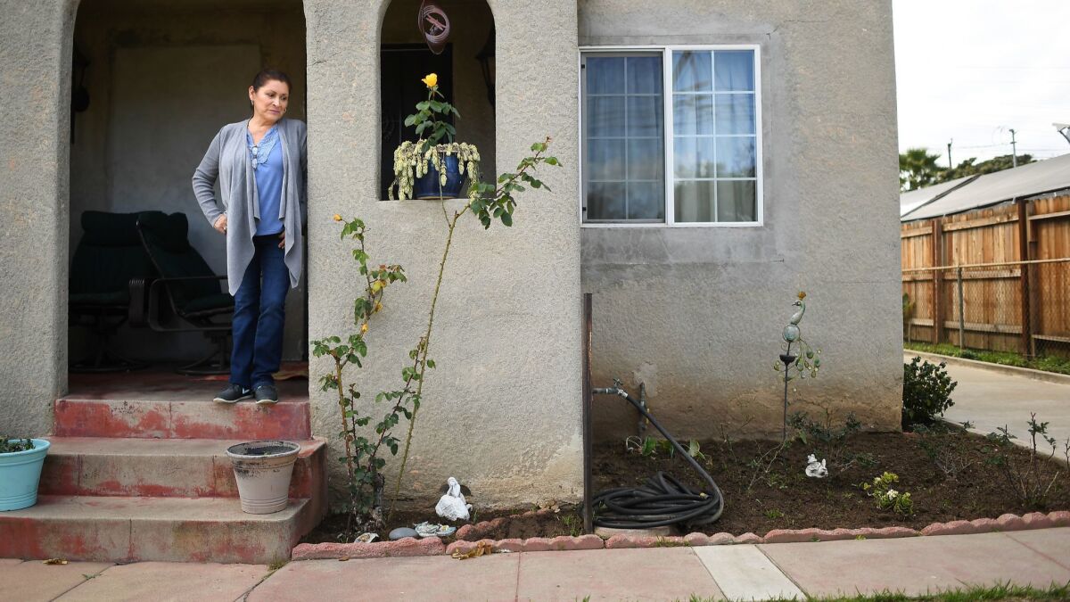 Herlinda Savarino, outside her home in East Los Angeles that is on a state cleanup list for lead-contaminated soil.