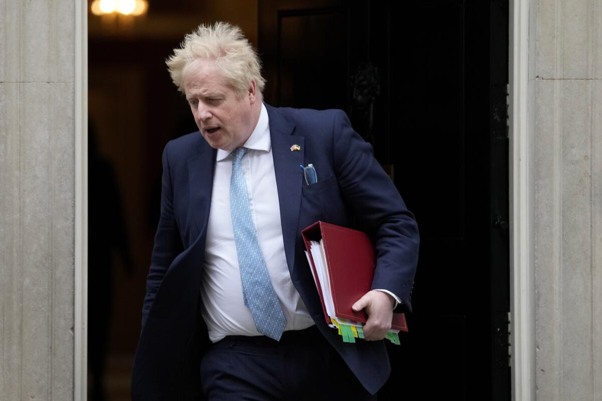 Prime Minister Boris Johnson walks out a door
