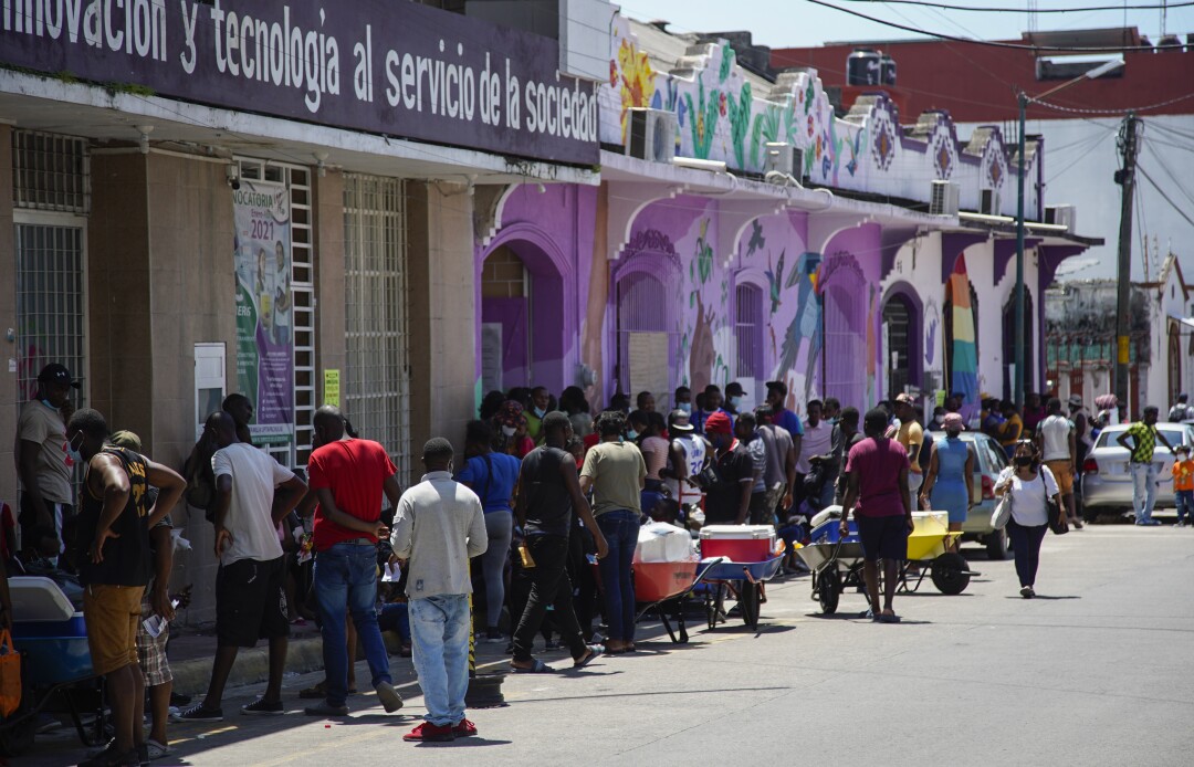 Haitians stand outside Human Rights Center Fray Matias de Cordova to get information
