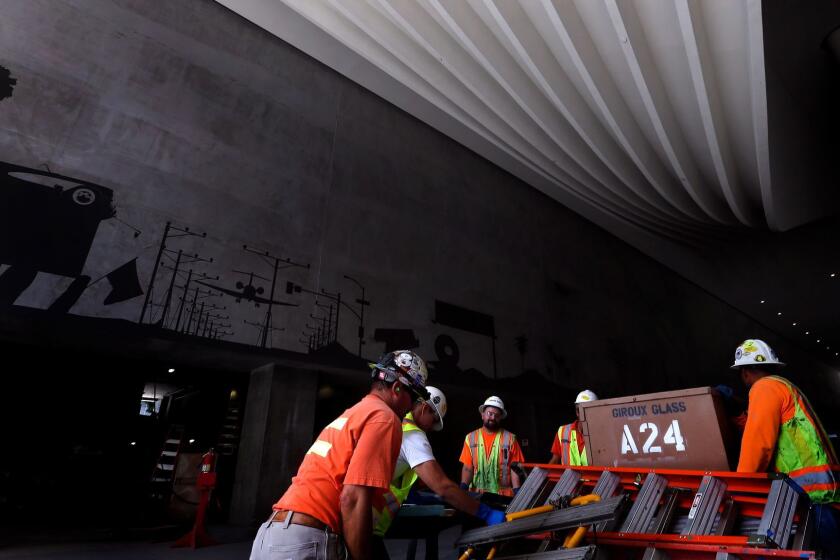 LOS ANGELES, CA-JUNE 1, 2017: Construction workers haul equipment whie working inside the porte cochere at the Wilshire Grand Center, in downtown Los Angeles on June 1, 2017. (Mel Melcon/Los Angeles Times)