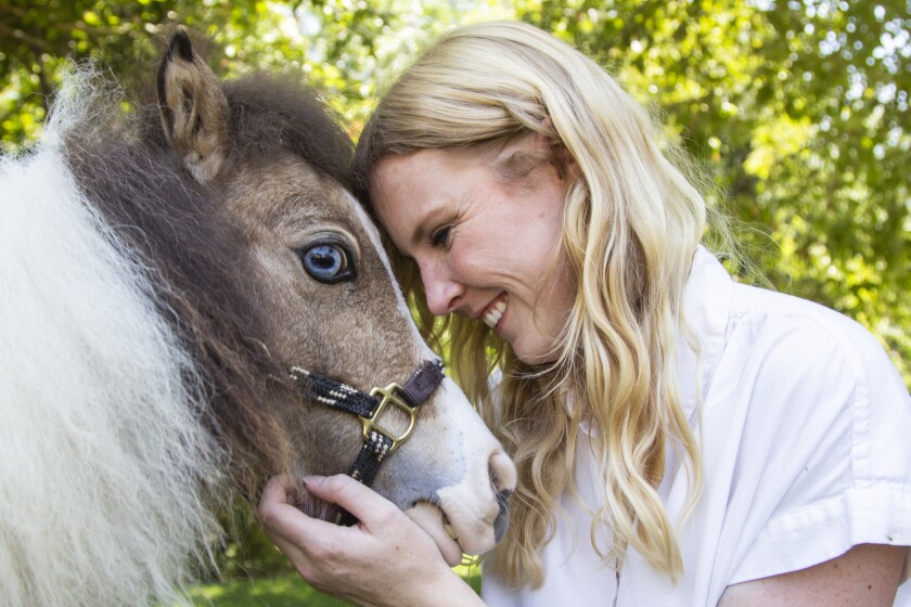 Savanah Stuart with Squeak, a miniature horse at Little Hooves Rescue Farm.
