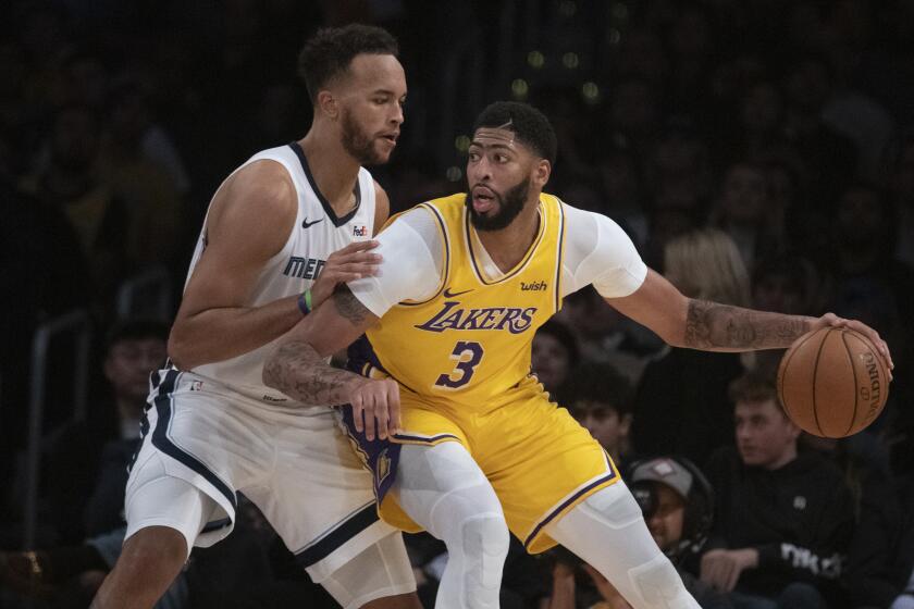 Los Angeles Lakers forward Anthony Davis, right, looks to dribble past Memphis Grizzlies forward Kyle Anderson in an NBA basketball game in Los Angeles, Tuesday, Oct. 29, 2019. (AP Photo/Kyusung Gong)
