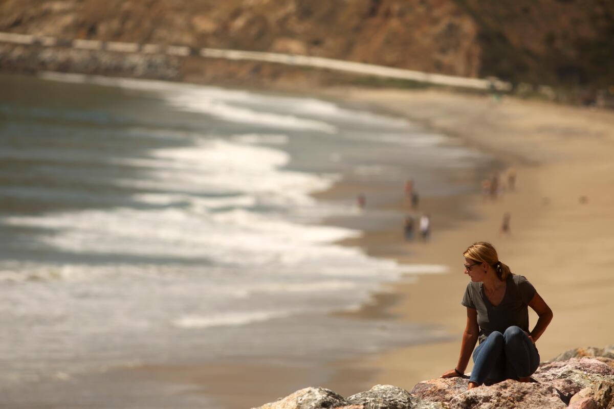 Manuela Sichau, of Santa Monica, enjoys a socially distant perch overlooking Point Mugu State Park along Pacific Coast Highway.