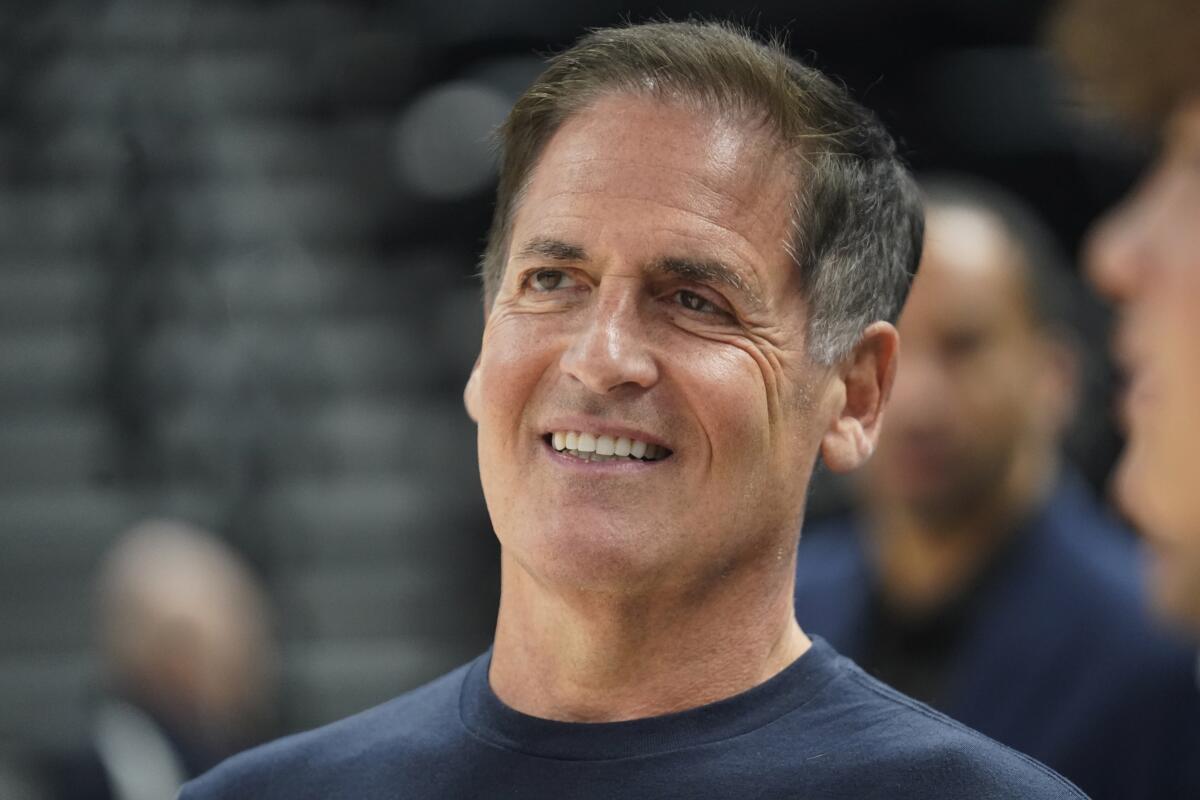 A smiling Mark Cuban looks off into the distance 