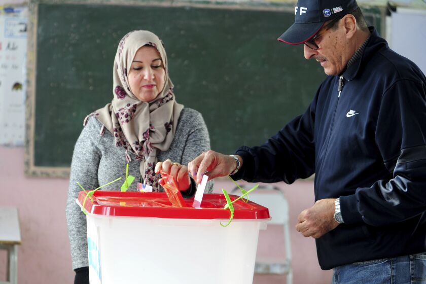 A Tunisian votes in the second round of the legislative elections in Tunis, Sunday, Jan. 29, 2023. Tunisia's president and its shaky democracy are facing an important test Sunday as voters cast ballots in the second round of parliamentary elections. Turnout was just 11% in the first round of voting last month. (AP Photo/Hassene Dridi)