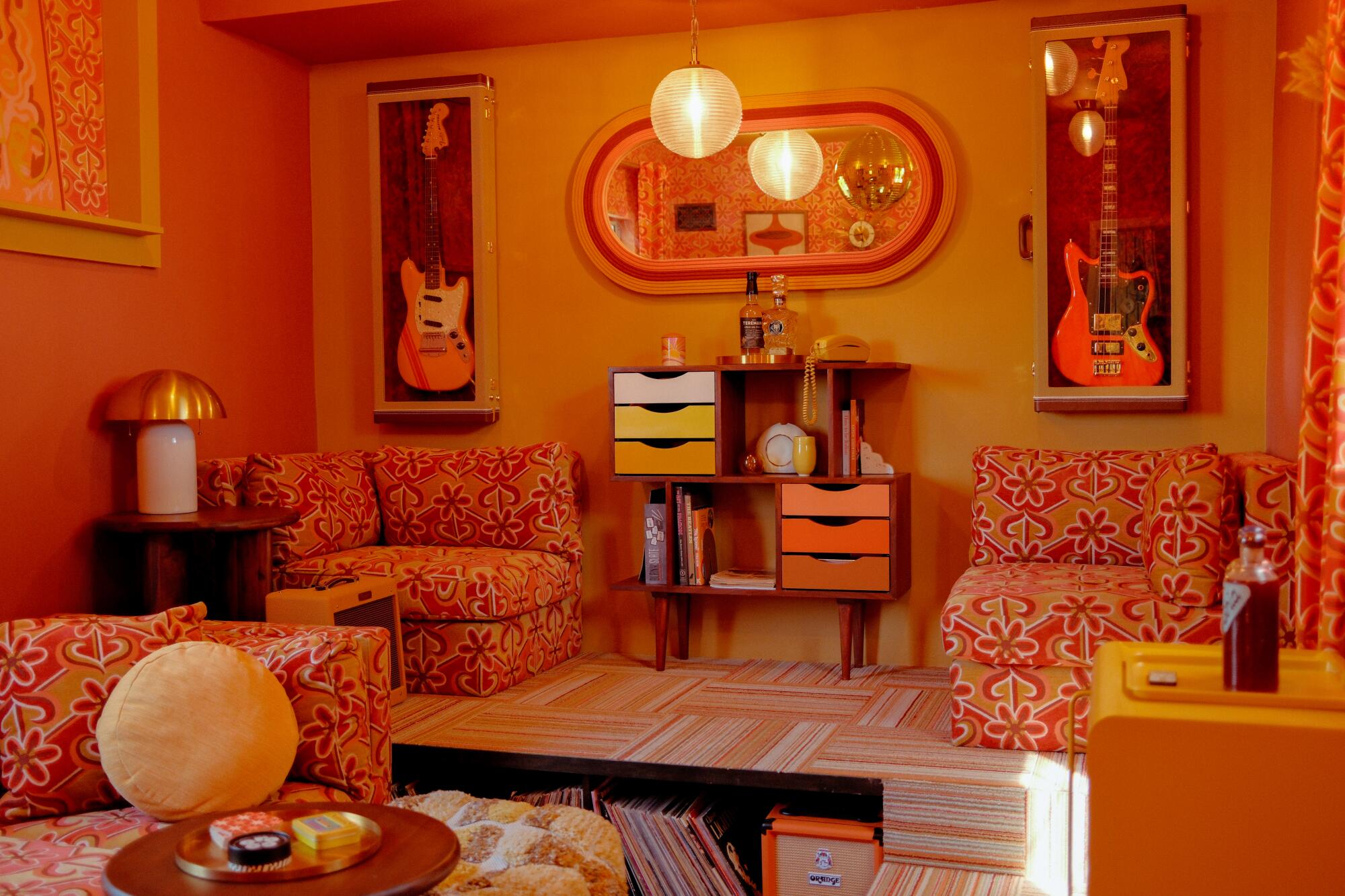 A retro red and orange room with guitars hanging on the wall