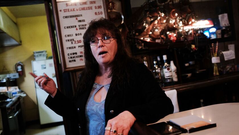 Kim Degler sits at the bar she runs outside Waynesburg, Pa., a once-thriving coal industry center that has struggled in the new energy era.